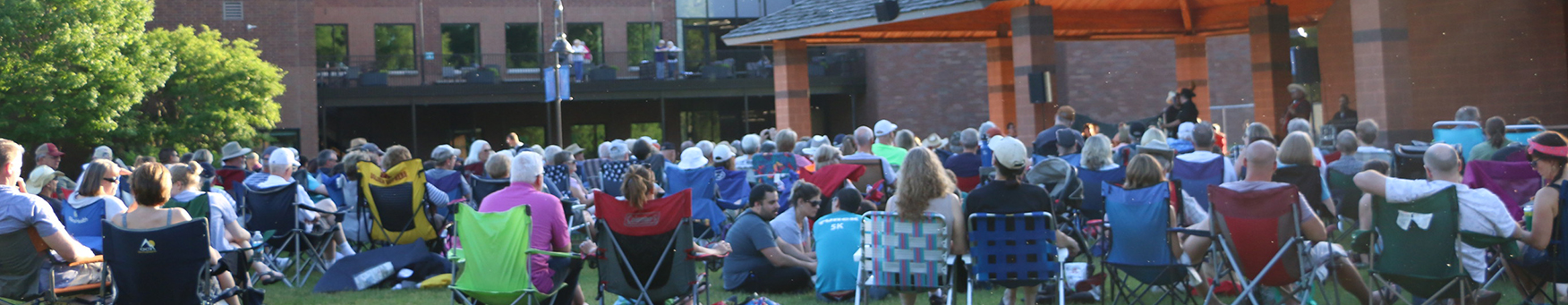 Summer concert at Shoreview Community Center with concert goers in folding chairs on the lawn